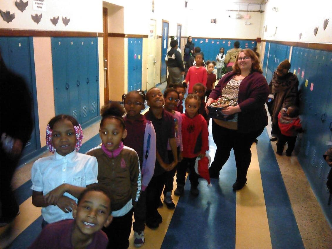 Students lined up and smiling in a school hallway