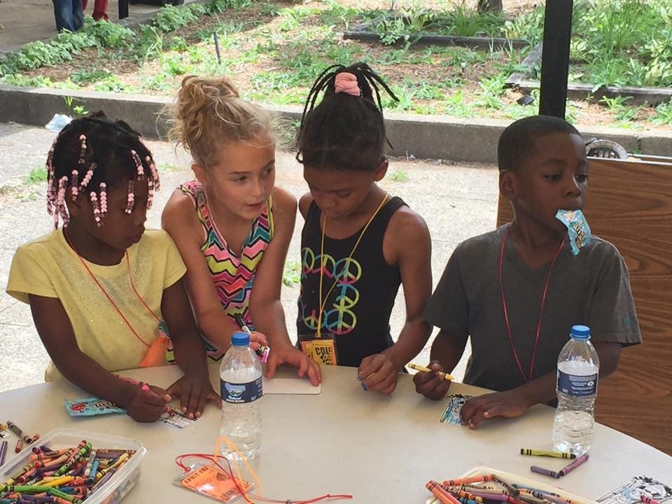 Kids making crafts together at an outdoor table