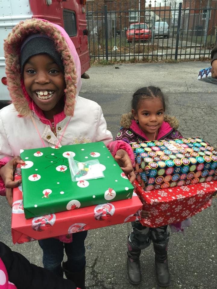 Two girls holding wrapped presents