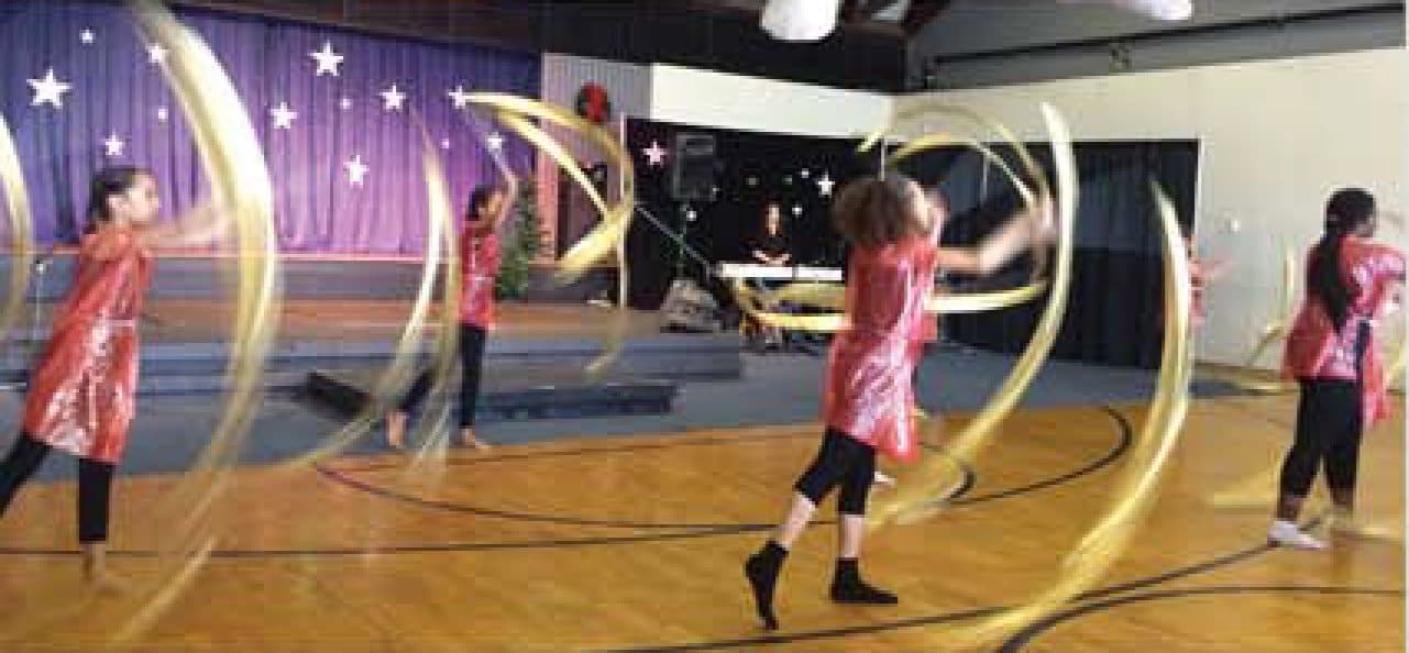Girls performing a ribbon dance on stage